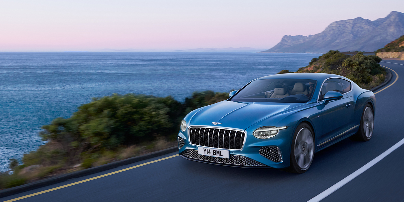 Bentley Rotterdam New Bentley Continental GT Azure coupe in Light Windsor blue paint with 22 inch Azure wheels and chrome grill, driving dynamically by the sea